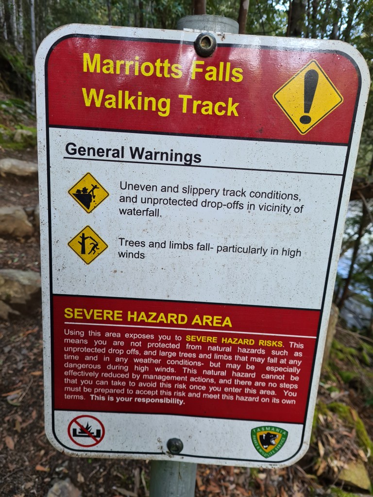 the Marriotts Falls severe hazard area warning sign reads "uneven and slippery track conditions, and unprotected drop=offs in vicinity of waterfall. Trees and limbs fall -- particulalry in high winds."