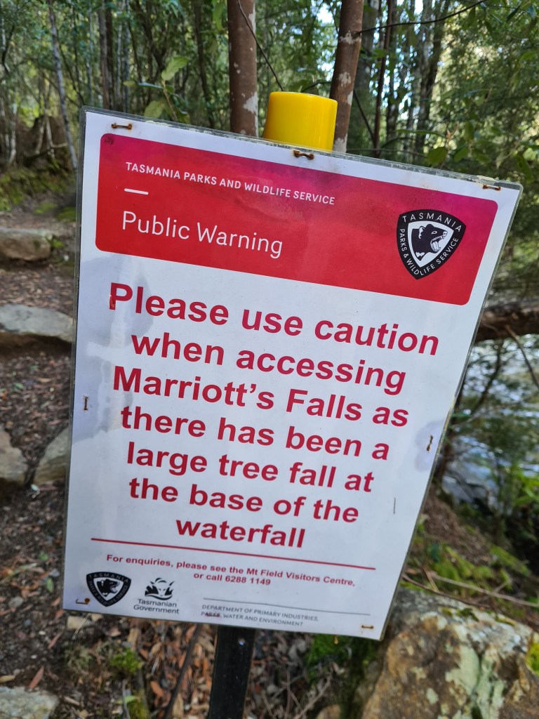 public warning sign which reads "please use caution when accessing Marriott's Falls as there has been a large tree fall at the base of the warerfall"