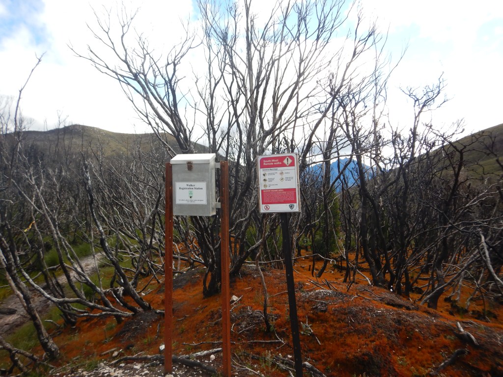 The Log book and a general warnings sign (unprotected cliffs and drop offs. Extreme and changeable weather. Falling trees and limbs. Wildfires. Creek and river levels rise and fall unexpectedly).