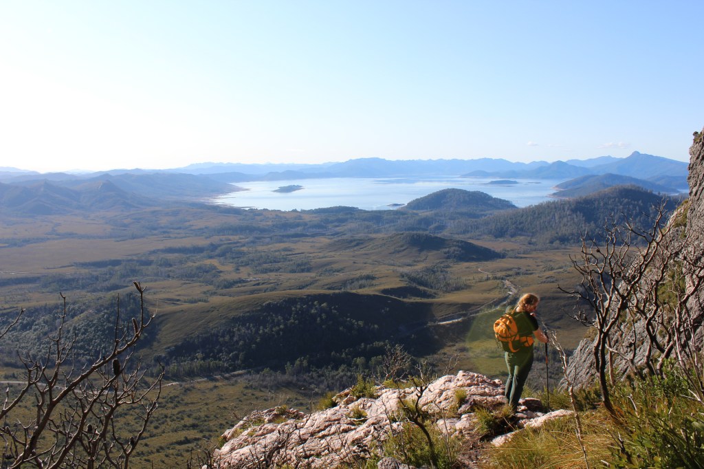 Sapphire rests against her hiking pole before descending a small cliff